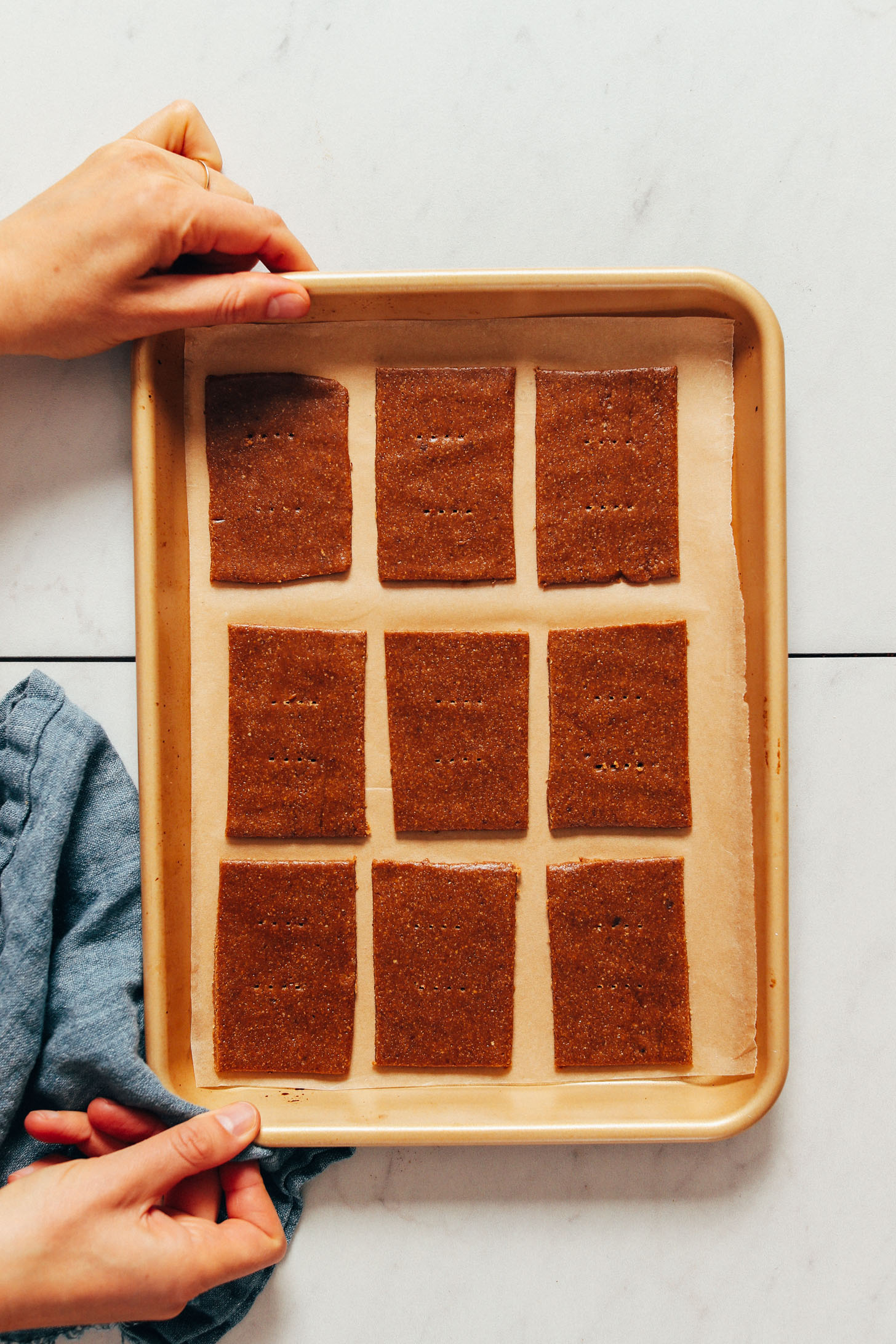 Gluten-free graham cracker dough on a parchment-lined baking sheet